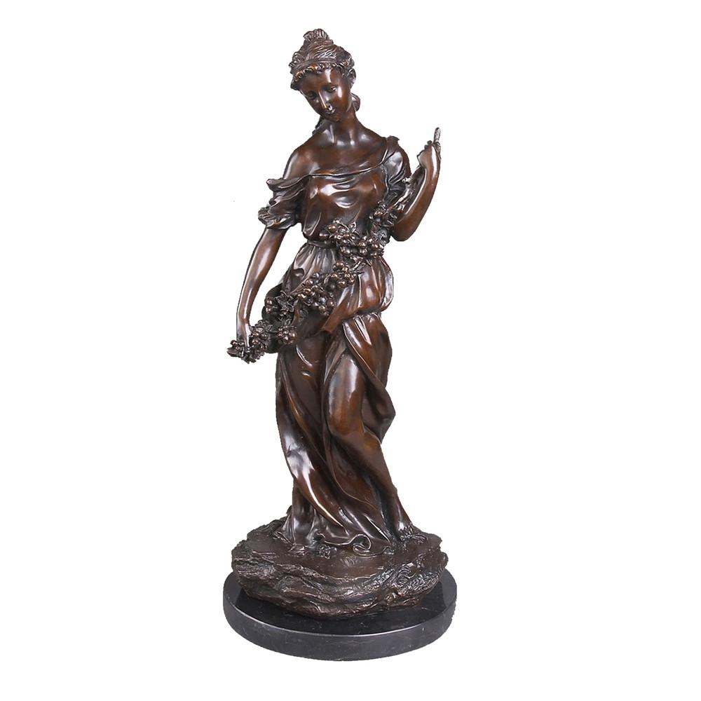This is a bronze sculpture of a standing woman, featuring European classical art style: the woman wears a flowing long dress, with delicate and realistic depictions of the fabric's fold textures; one hand holds a bunch of grapes full of fruits, showcasing a stretched and soft posture, and a gentle and tranquil demeanor. This work is often used as a home decorative ornament, combining artistic beauty and decorative value.