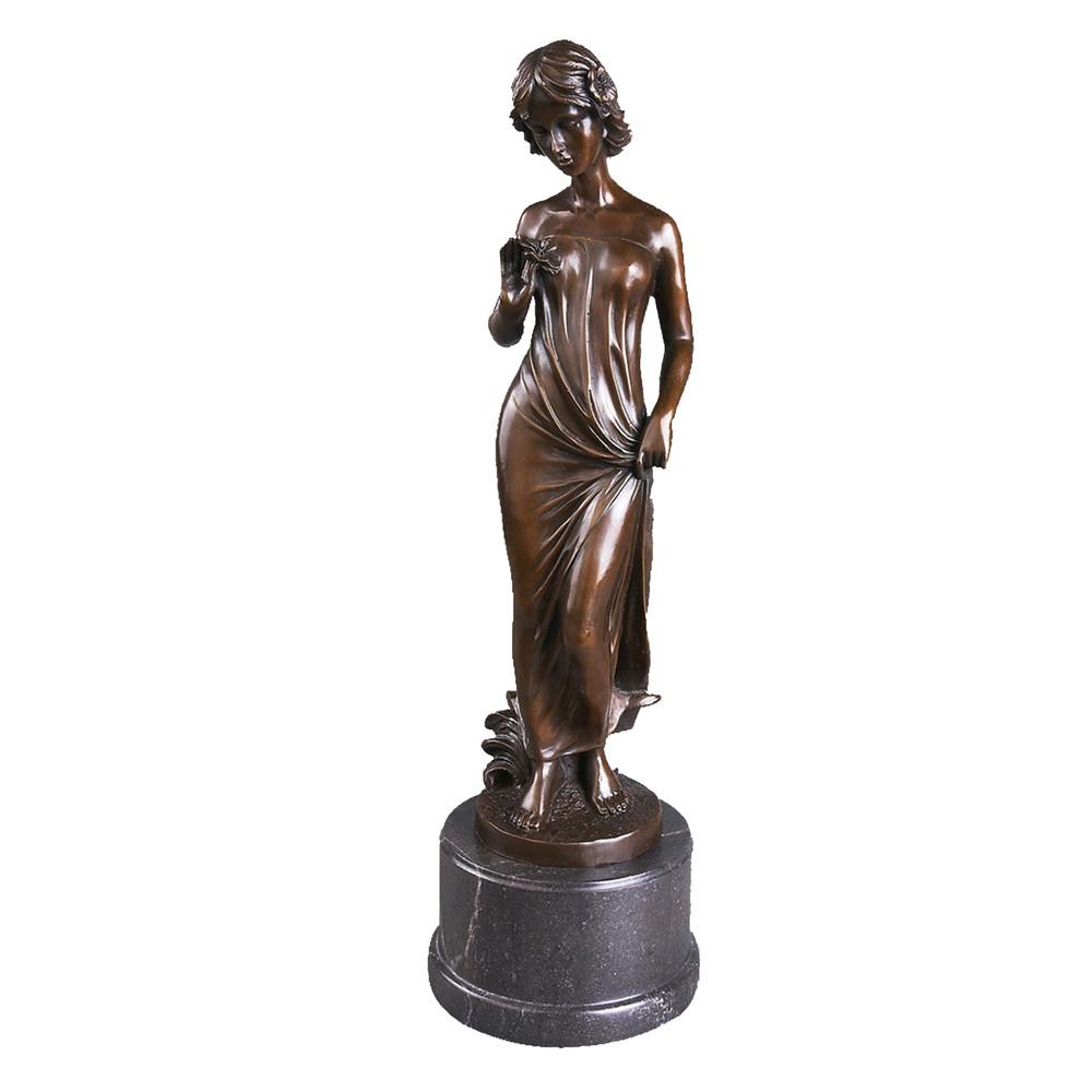 This is a bronze sculpture of a standing woman. She wears a wrap-around long dress, and the fold textures of the fabric are delicately and realistically depicted; one hand gently holds a flower, while the other adjusts the skirt, with a decoration in her hair, exuding a gentle and soft demeanor that fully shows elegant charm. TThis work is often used as a European-style home decorative ornament, combining artistic beauty and decorative value.